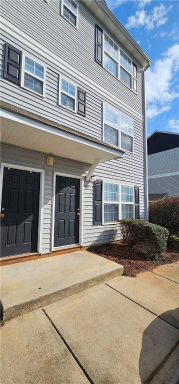 property entrance featuring concrete driveway and an attached garage