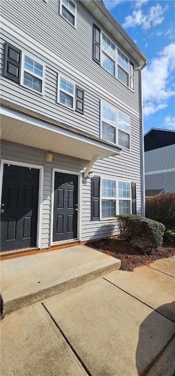 doorway to property with concrete driveway and an attached garage