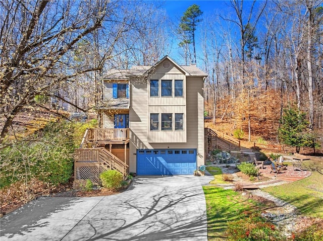 view of front of property featuring stairs, aphalt driveway, and a garage