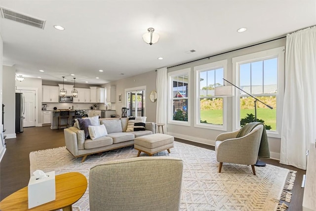 living room with plenty of natural light, visible vents, and recessed lighting