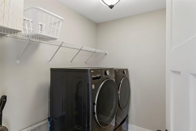 laundry room with laundry area, baseboards, and washer and clothes dryer