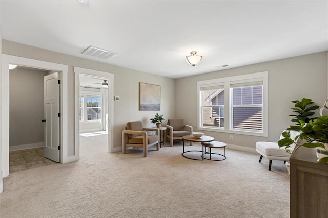 living area featuring carpet floors, visible vents, and baseboards