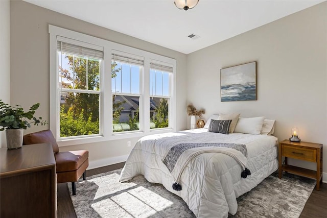 bedroom with visible vents, baseboards, and wood finished floors