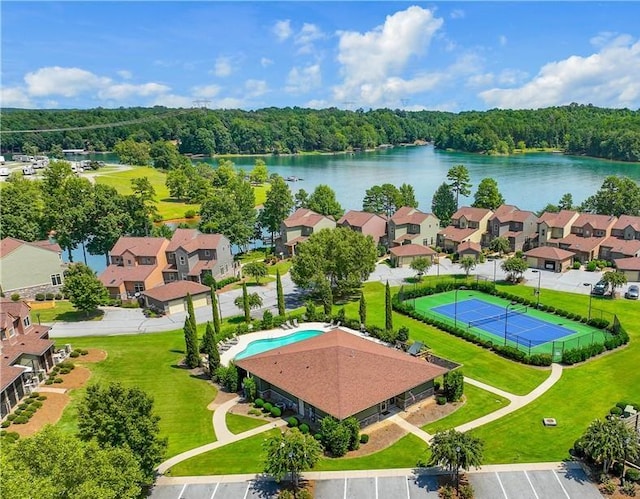 drone / aerial view with a water view, a residential view, and a view of trees