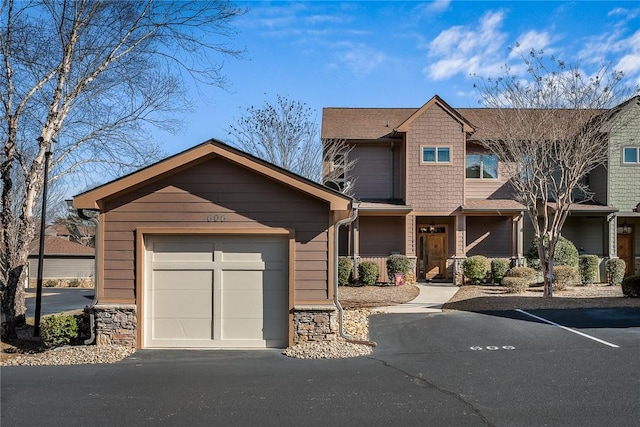 view of front of property with a garage and stone siding