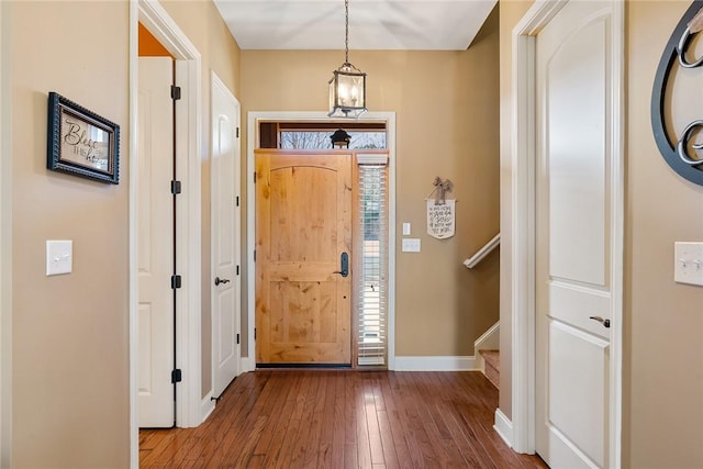 entryway featuring wood-type flooring, stairs, and baseboards