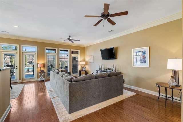 living area with dark wood-style floors, visible vents, ornamental molding, ceiling fan, and baseboards