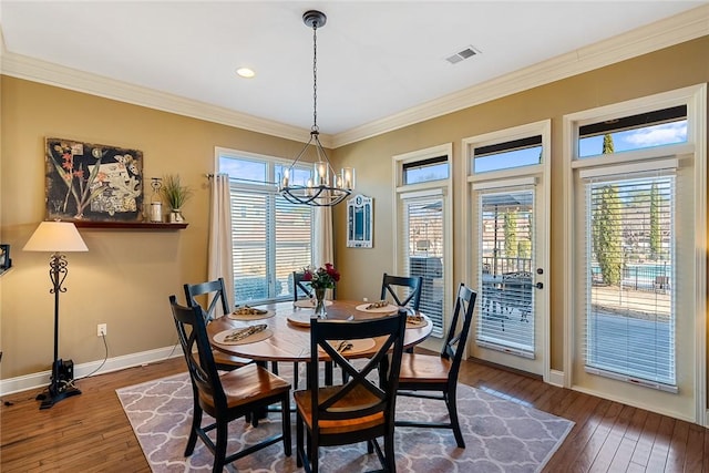 dining room with ornamental molding, dark wood-style flooring, visible vents, and baseboards