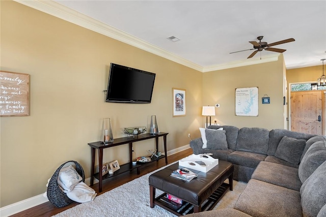 living room featuring visible vents, crown molding, baseboards, and wood finished floors