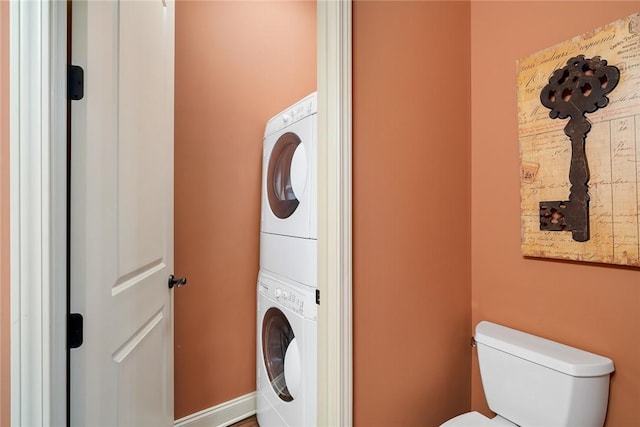 clothes washing area with stacked washing maching and dryer