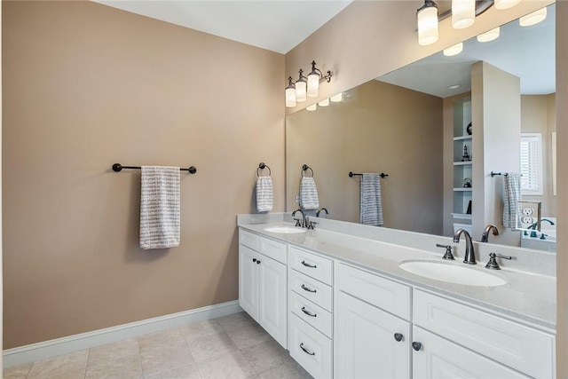 full bath featuring tile patterned flooring, a sink, baseboards, and double vanity