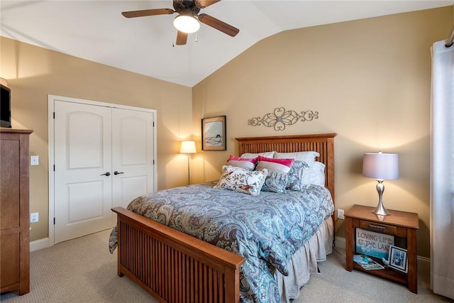 carpeted bedroom with lofted ceiling, a closet, a ceiling fan, and baseboards