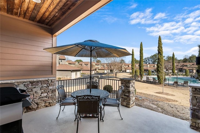 view of patio / terrace featuring a grill, a community pool, a residential view, and outdoor dining area