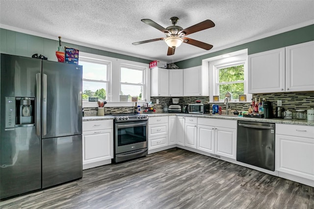 kitchen with dark wood-style floors, appliances with stainless steel finishes, a sink, and a wealth of natural light