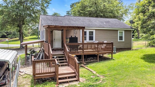 back of property featuring a lawn, roof with shingles, fence, a deck, and central AC