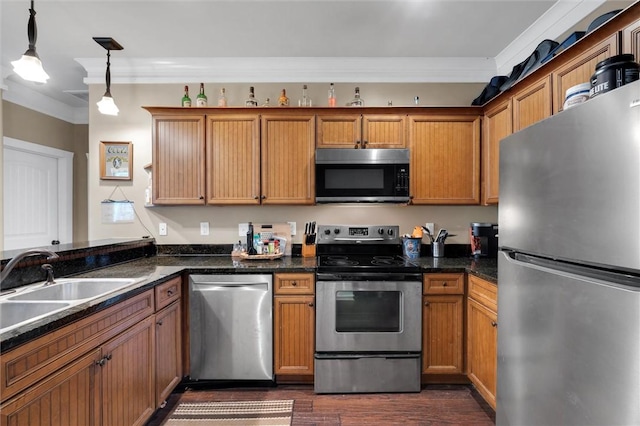 kitchen with brown cabinetry, dark wood-style floors, stainless steel appliances, crown molding, and a sink