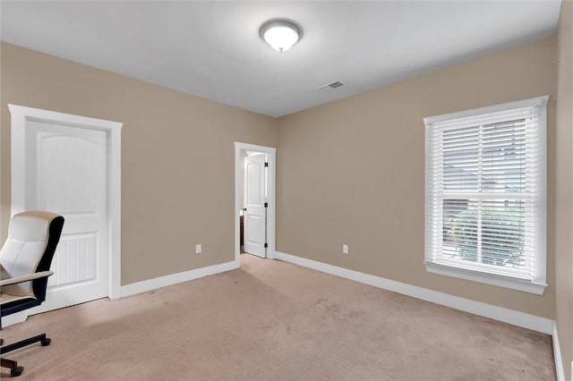 unfurnished office with light colored carpet, visible vents, and baseboards