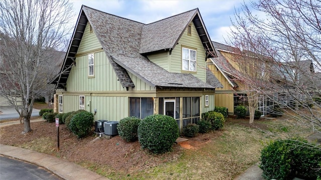 view of side of property with board and batten siding and roof with shingles