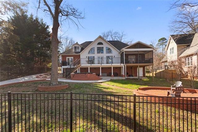 rear view of property with a patio, a fenced front yard, a sunroom, stairs, and a yard