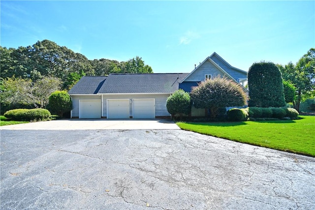 view of front facade with a garage, driveway, and a front yard