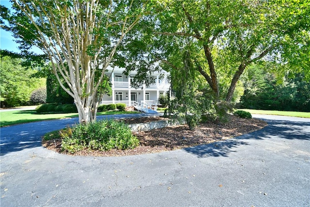 obstructed view of property with driveway, covered porch, and a balcony