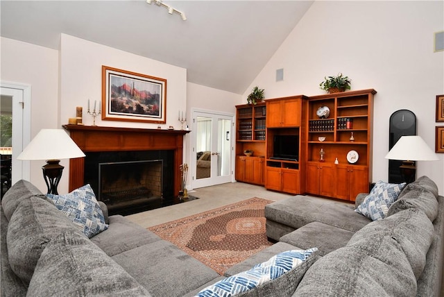 living area featuring a fireplace with flush hearth, light carpet, and high vaulted ceiling