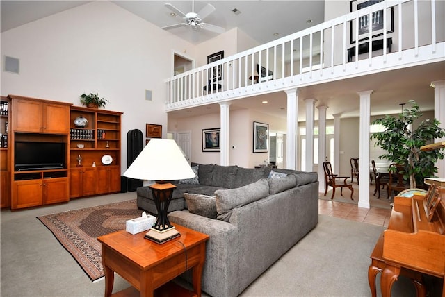 living area featuring a high ceiling, ceiling fan, and ornate columns