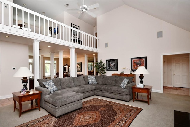 carpeted living area featuring visible vents, baseboards, a ceiling fan, and ornate columns