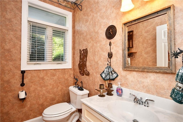 half bath featuring vanity and toilet