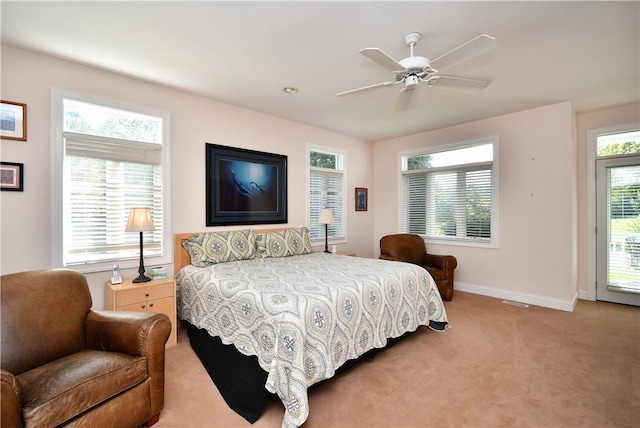 bedroom with light carpet, ceiling fan, visible vents, and baseboards