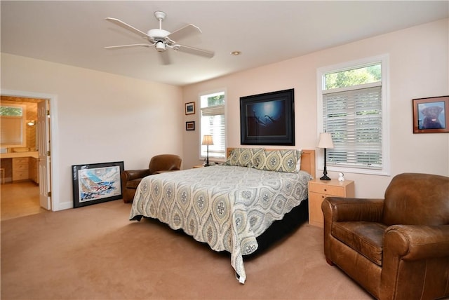 bedroom with ensuite bath, ceiling fan, and light colored carpet