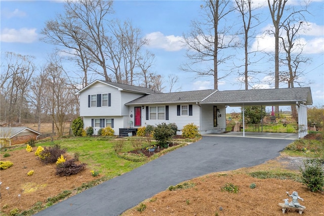 split level home featuring driveway, an attached carport, and a shingled roof