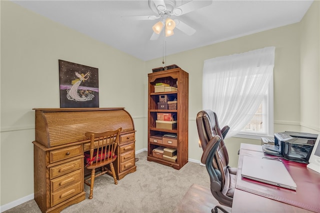 carpeted home office with ceiling fan and baseboards