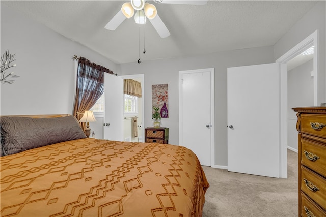 bedroom featuring a textured ceiling, a ceiling fan, and light colored carpet