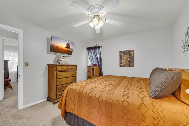 bedroom featuring a textured ceiling, ceiling fan, baseboards, and light colored carpet