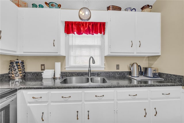 kitchen with electric range, dark countertops, a sink, and white cabinets