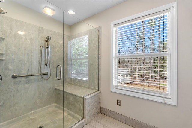 bathroom with baseboards and a marble finish shower