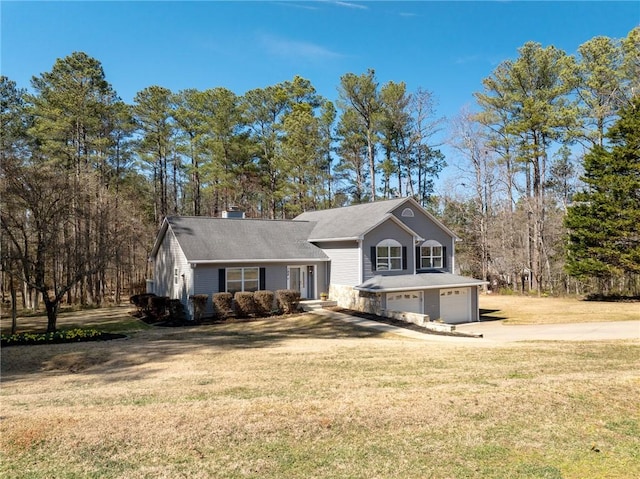 view of front of property featuring concrete driveway, an attached garage, and a front yard