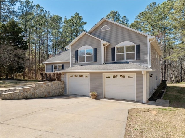 traditional-style home featuring concrete driveway and an attached garage