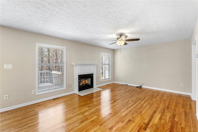 unfurnished living room featuring a fireplace with flush hearth, visible vents, light wood-style flooring, and baseboards