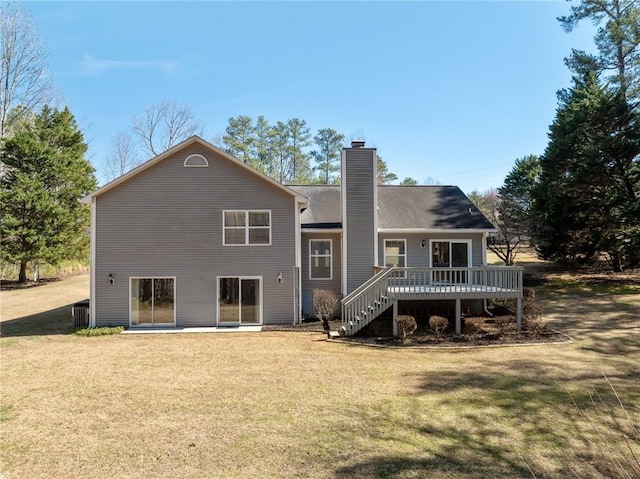 rear view of house featuring stairs, a lawn, a chimney, and a wooden deck