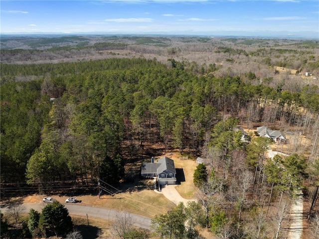 bird's eye view with a wooded view