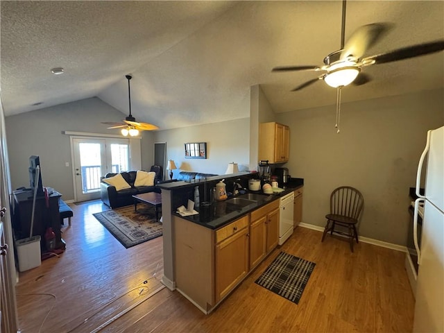 kitchen with lofted ceiling, white appliances, a textured ceiling, and wood finished floors