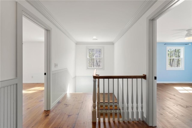 corridor featuring crown molding, an upstairs landing, and hardwood / wood-style flooring