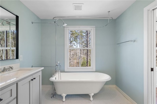 bathroom featuring a freestanding tub, visible vents, and a healthy amount of sunlight