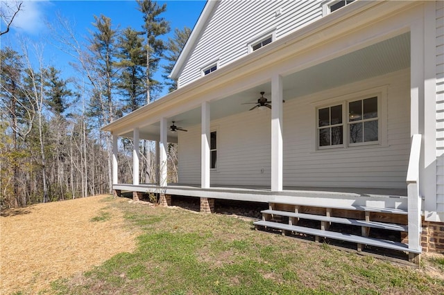 exterior space featuring ceiling fan and a lawn