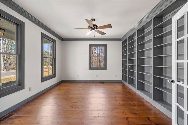 unfurnished room featuring hardwood / wood-style floors, a ceiling fan, baseboards, and ornamental molding