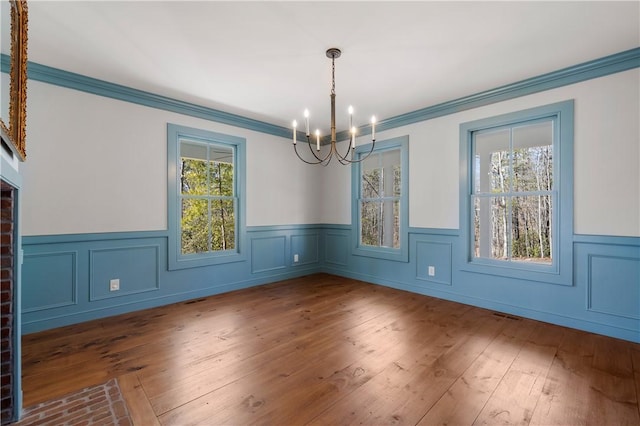 unfurnished dining area with a chandelier, hardwood / wood-style floors, and a wealth of natural light