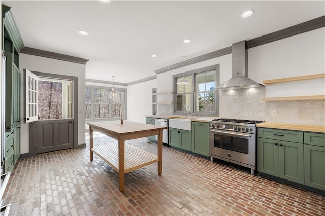 kitchen with open shelves, wall chimney exhaust hood, stainless steel appliances, and green cabinets