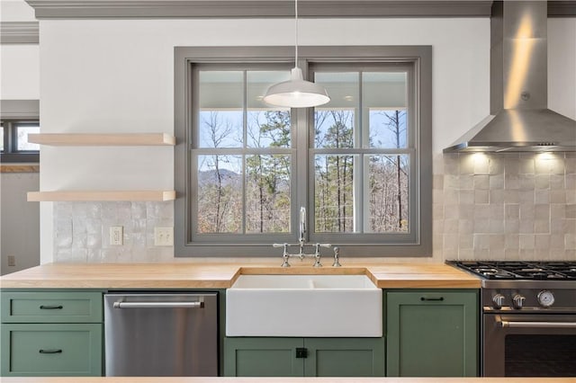 kitchen featuring stainless steel appliances, wall chimney range hood, and green cabinetry